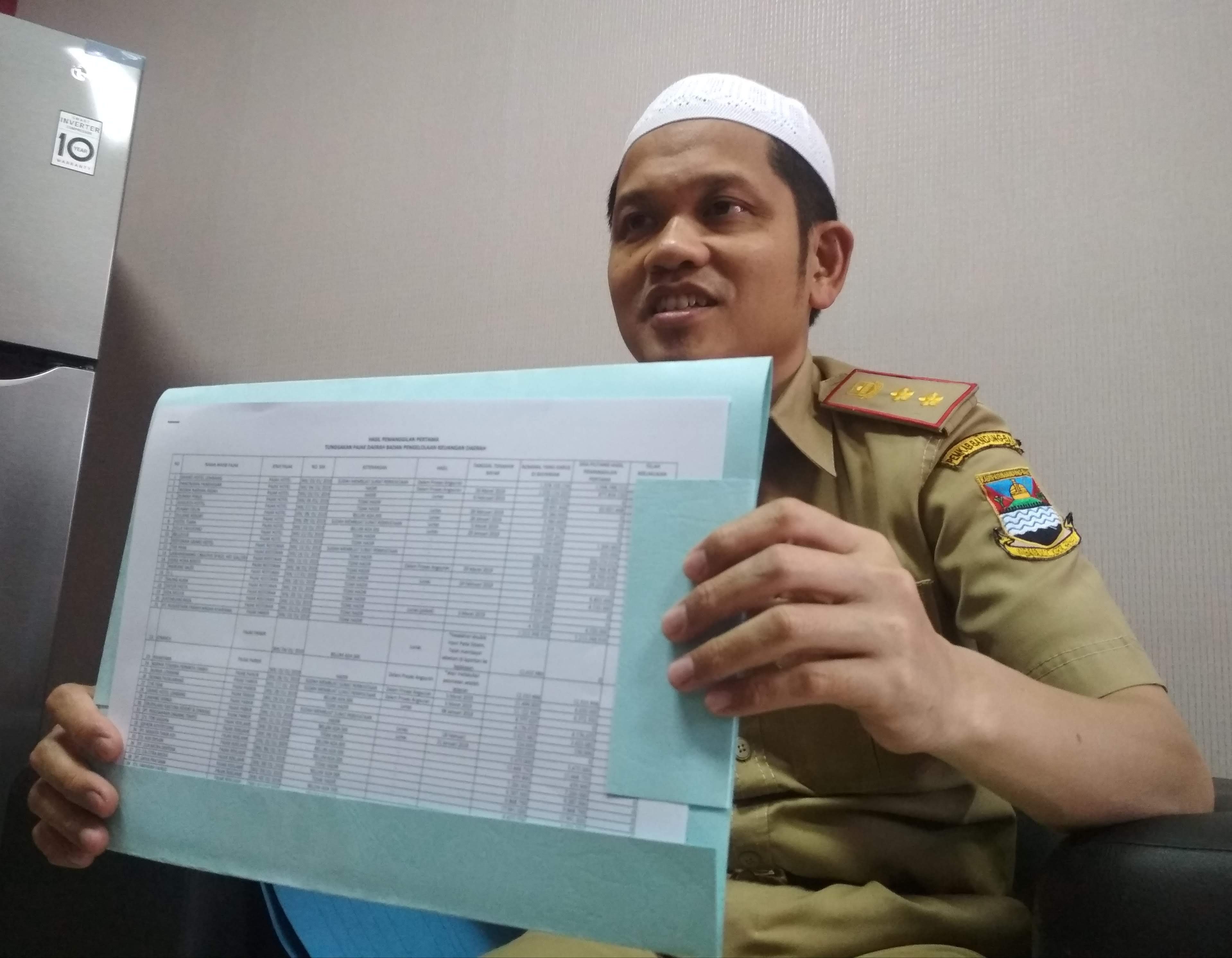 Kabid Pendapatan pada BPKD Kabupaten Bandung Barat, Hasanudin menunjukkan data wajib pajak yang belum memenuhi kewajibannya. (foto: M Zein/dara.co.id)
