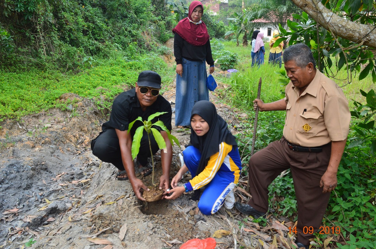 Agus Suparmanto (paling kiri), kepala sekolah SMP 04 Tenggarong, berfoto bersama siswa dan orang tua siswa yang akan menanam pohon di lahan sekolah (Foto: Istimewa)