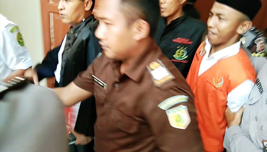 Jajang (rompi jingga) menebar senyum seusai vonis mati yang dijatuhkan majelis hakim Pengadilan Negeri Garut, Senin (14/10/2019). Foto: dara.co.id/Beni