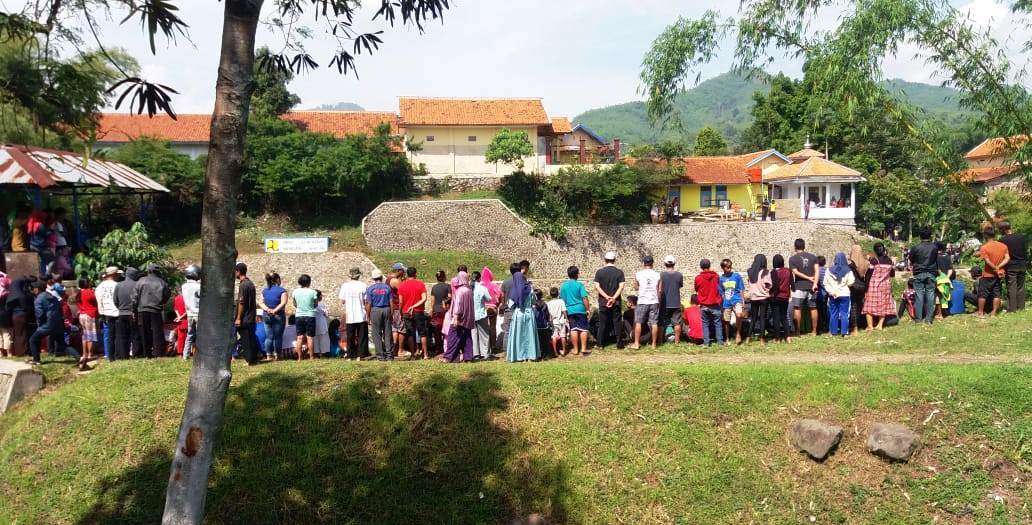 Warga berkerumun di pinggir sungai menyaksikan evakuasi mayat yang mengambang di pintu air sungai tersebut. Foto: dara.co.id/Fattah