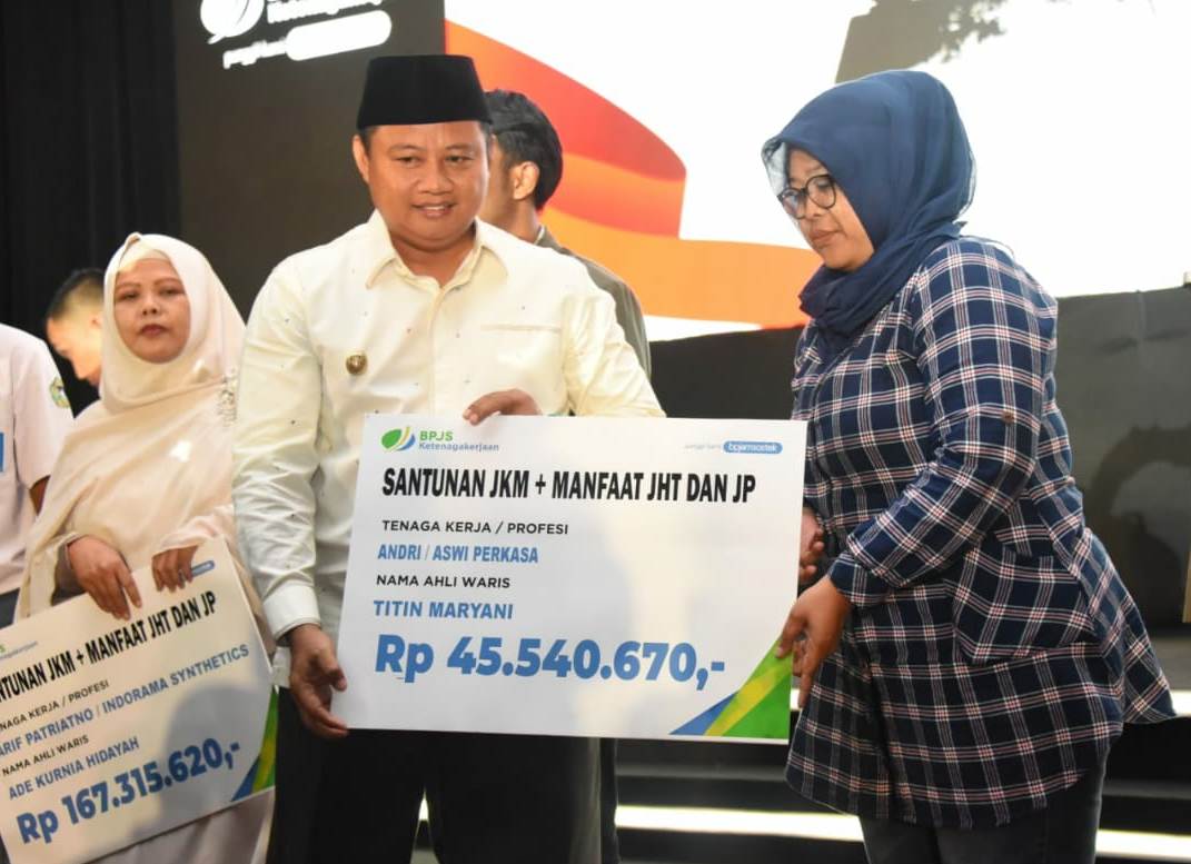 Plh Gubernur Jawa Barat, Uu Ruzhanul Ulum secara simbolis menyerahkan santunan kepada ahli waris pekerja pada acara Sosialisasi PP Nomor 82 Tahun 2019 BPJamsostek di The Trans Luxury Hotel, Kota Bandung, Selasa (25/2/2020). Foto: Istimewa
