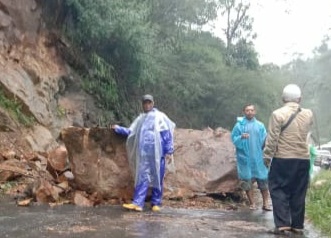 Sejumlah warga tengah berfoto di lokasi longsor batu yang menutup Jalan Cikajang-Pameungpeuk, Kabupaten Garut, Jawa Barat, Selasa (25/2/2020). Foto: Beni/Istimewa