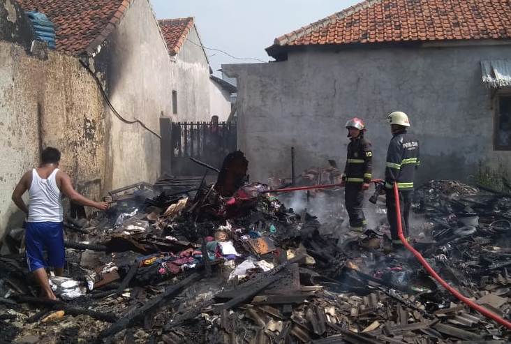 Seorang petugas kebakaran dari DIsdamkar Kabupaten Bandung melakukan pendinginan satu unit rumah yang terbakar di Kampung Pameuntasan RT 02/RW 12, Desa pameuntasan, Kecamatan Kutawaringin, Kabupaten Bandung, Jawa Barat, Selasa (3/3/2020). (Foto: Pusdalops Disdamkar Kabupaten Bandung)