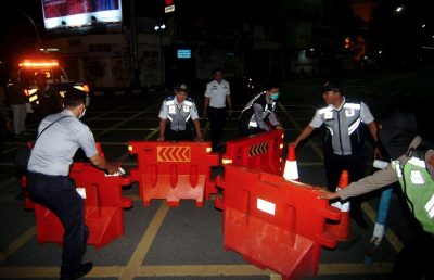 Petugas melakukan pengalihan jalur saat penutupan sebagian jalan protokol Kota Tegal, Jawa Tengah, Senin (22/3/2020) malam. (Foto : alinea.id