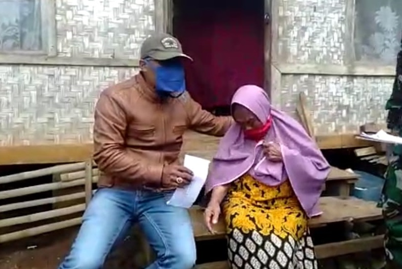 Petugas Desa Sukajaya, Kecamatan Sukaresmi, Kabupaten Garut, Jawa Barat, menyerahkan amplop bantuan langsung tunai (BLT) kepada Mak Ijah. (Foto: Beni/dara.co.id)
