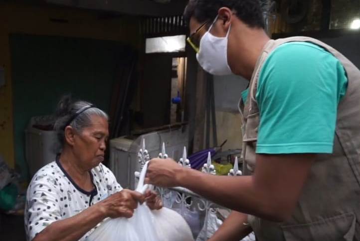Seorang relawan Yayasan Senyum Indonesia saat menyerahkan bantuan kepada lansia warga RW 03 Desa/Kecamatan Cangkuang, Kabupaten Bandung, Jawa Barat, Ahad (10/5/2020). (Foto: Verawati/dara.co.id)