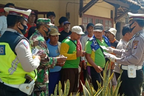 Dua anggota POlsek Pamanukan, Resort Subang membagikan masker kepada para karyawan di gudang pupuk kujang di di Desa Mandalawangi, Kecamatan Sukasari, Kabupaten Subang, Jawa Barat, Senin (3/8/2020). (Foto: Yudi/dara.co.id)
