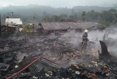 Seorang petugas pemadam kebakaran tengah melakukan pendinginan setelah kebakaran cukup besar meludeskan sejumlah rumah di Desa Patengan, Kecamatan Rancabali, Kabupaten Bandung, Jawa Barat, Senin (10/8/2020). (Foto: Pusdalops Disdamkar Kabupaten Bandung)