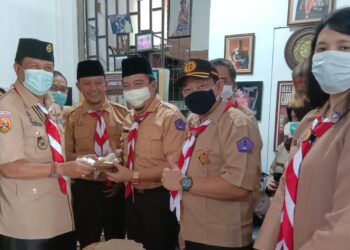 Ketua Kwarcab Gerakan Pramuka KBB Aseng Junaedi, memberikan potongan tumpeng pada Ketua Mabi Pariwisata, Heri Partomo, usai pelantikan Saka Pariwisata, Selasa (16/2/2021). (Foto : Heny/dara.co.id)