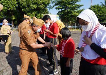 Bupati Garut, Rudy Gunawan, mengalungkan medali kepada kontingen Kabupaten Garut yang telah meraih prestasi pada Virtual Special Olympic Indonesia (SOIna)Tingkat Nasional Tahun 2020 di Lapang Setda Kabupaten Garut, Senin (26/4/2021) (Foto: Istimewa)