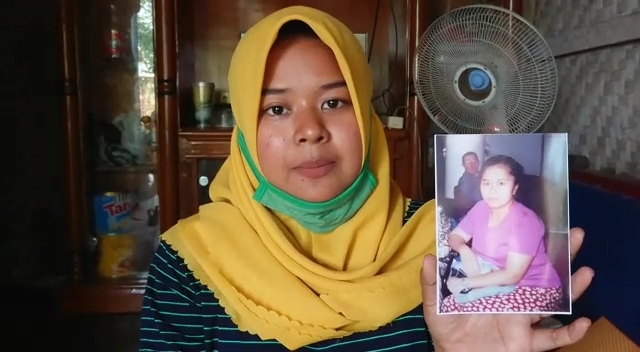 
Sinta memperhatikan foto ibunya Ani Iam Hamdanah yang pergi tak ada kabar berita belasan tahun. (Foto : purwanda/dara.co.id)
