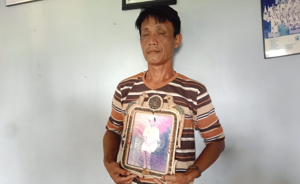 Paman Korban, Ahmad Saputra (51) saat memegang foto korban (Foto: Purwanda/dara.co.id)