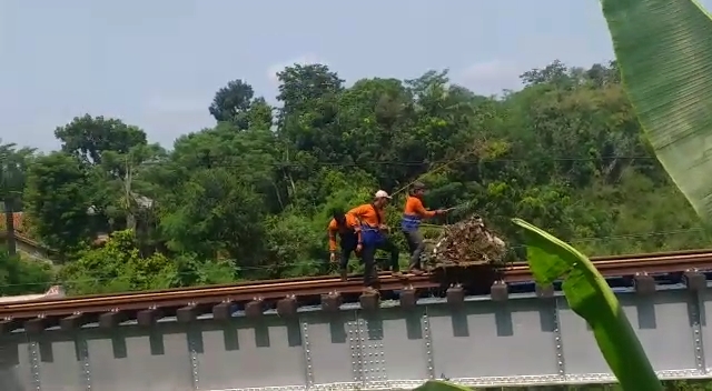Tiga petugas kebersihan dari PT KAI membuang sampah ke sungai Cisokan (Foto: Istimewa)