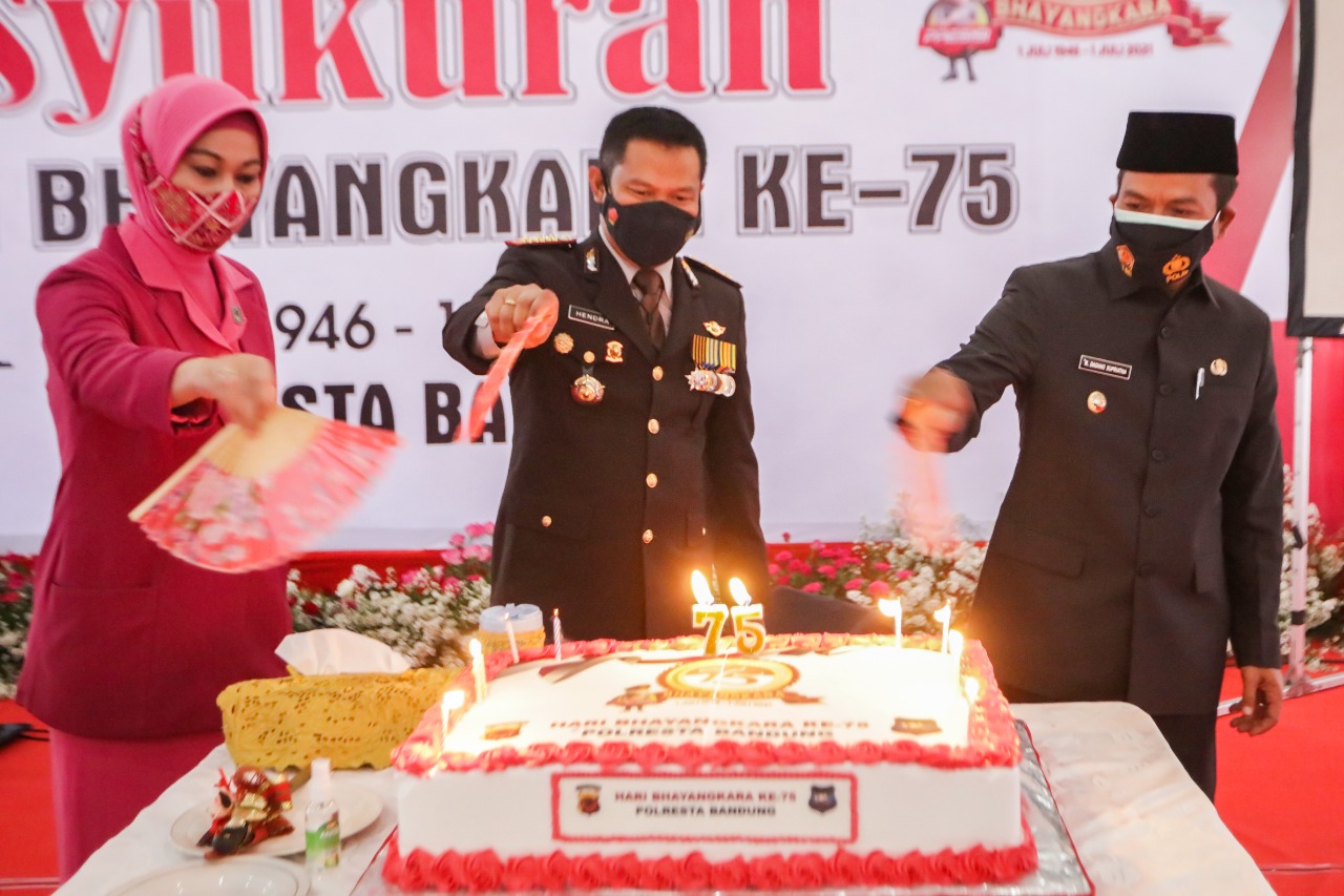 
Kapolresta Kombes Pol Hendra Kurniawan, didampingi istri Ny. Rina Hendra Kurniawan, bersama Bupati Bandung HM Dadang Supriatna memotong kue Ulang Tahun ke-75 Hari Bhayangkara di Markas Komando (Mako) Polresta Bandung, Jalan Raya Bhayangkara, Soreang, Kamis (1/7/2021). (Foto : Humas Pemkab Bandung)
