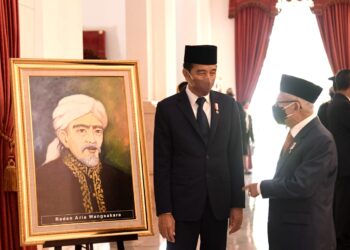 Presiden Jokowi berbincang dengan Wakil Presiden Ma’ruf Amin di depan lukisan Raden Aria Wangsakara, Pahlawan Nasional dari Banten, yang baru saja dianugerahkan pada Rabu (10/11/2021). (Foto: BPMI Setpres/Rusman)