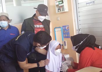 Hengky Kurniawan saat membujuk anak SD yang takut divaksin (Foto: Istimewa)