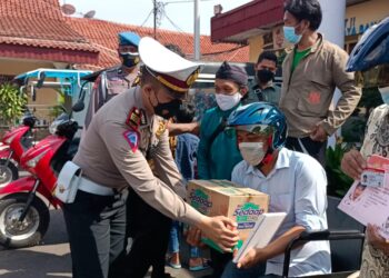 Kasat Lantas Polres Cirebon Kota AKP Triyono Raharja menyerahkan bantuan sembako kepada penyandang disabilitas (Foto: Istimewa)