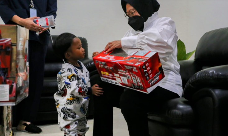 Mensos Tri Rismaharini saat memperlihatkan mainan kepada anak yang terlahir tanpa anus (Foto: Kemensos)