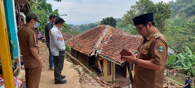 Kepala Pelaksana BPBD Kabupaten Bandung Uka Suska Puji Utama meninjau dan memberikan bantuan kepada korban longsor di Desa Ciheulang RT 17/RW 01 Kecamatan Ciparay, Kabupaten Bandung, Selasa (12/4/2022). (Foto: BPBD Kab. Bandung)
