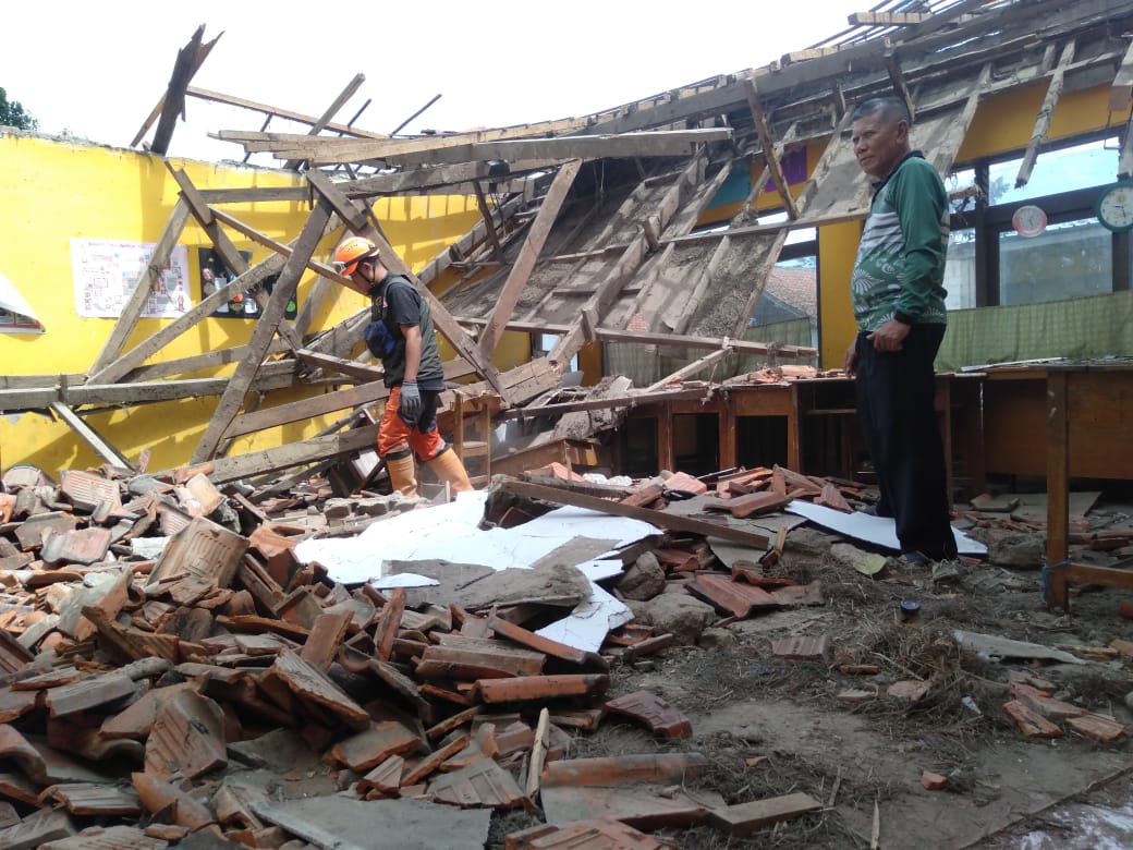 
Sejumlah relawan dari anggota Pramuka sedang membereskan puing-puing dari sisa atap bangunan SDN Rancanilem yang ambruk di Kampung Rancanilem, Desa Bojongloa Kecamatan Rancaekek Kabupaten Bandung, Minggu (29/5/2022).(Foto: trinata/dara.co.id)
