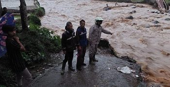 Petugas menunujukan jembatan darurat yang kembali ambrol di Kecamatan Banjarwangi usai hujan dengan intensitas tinggi mengguyur wilayah tersebut, Jumat (12/8/2022) sore.(Foto: andre/dara.co.id)