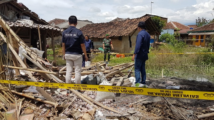 Petuas dari Polres Sukabumi memasang Police Line di sekitar lokasi rumah yang terbakar akibat petasan (Foto: dyan/dara.co.id)
