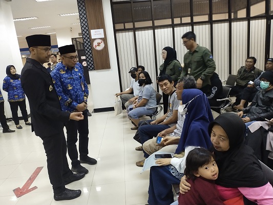 
Bupati Bandung Barat berbincang dengan masyarakat yang sedang mengurus surat-surat kependudukan. (Foto: heny/dara)