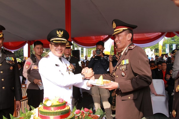 Bupati Bandung Dr. HM. Dadang Supriatna memberikan potongan nasi tumpeng kepada Plt. Kapolresta Bandung AKBP Indra Hermawan, pada 
Peringatan Hari Jadi ke-77 Bhayangkara di Lapangan Upakarti Komplek Pemkab Bandung, Soreang, Sabtu (1/7/2023). (Foto: prokpimda)
