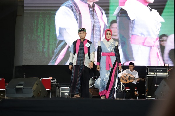 Kepala Dinas Komimfo Kabupaten Bandung Yosep Nugraha dan istri beraksi di atas catwalk pada Fashion show Festival Muharam menyambut Tahun Baru Islam 1445 Hijriyah di Dome Bale Rame Soreang, Kabupaten Bandung, Selasa  (18/7/2023). (Foto: prokopim)