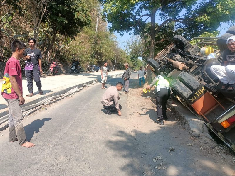 Petugas dari Unit Laka Lantas Satlantas Polres Garut melakukan olah tempat kejadian perkara (TKP) kecelakaan truk yang terguling menimpa sepeda motor di Jalan Raya Banyuresmi, Kabupaten Garut, Selasa (5/9/2023)(Foto: Istimewa)