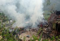 
Warga berjibaku memadamkan kobaran api yang membakar tiga rumah panggung di Kampung Cikiruh, Desa Sukamulya, Kecamatan Talegong, Kabupaten Garut, Kamis pagi (5/9) pagi. (Foto: andre/dara)
