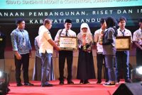 
Kepala Bapperida Kabupaten Bandung, Marlan menyerahkan penghagaan kepada pemenang KIKB 2024, yang digelar di Grand Sunshine Soreang, Rabu (30/10/2024).(Foto: diskominfo) 
