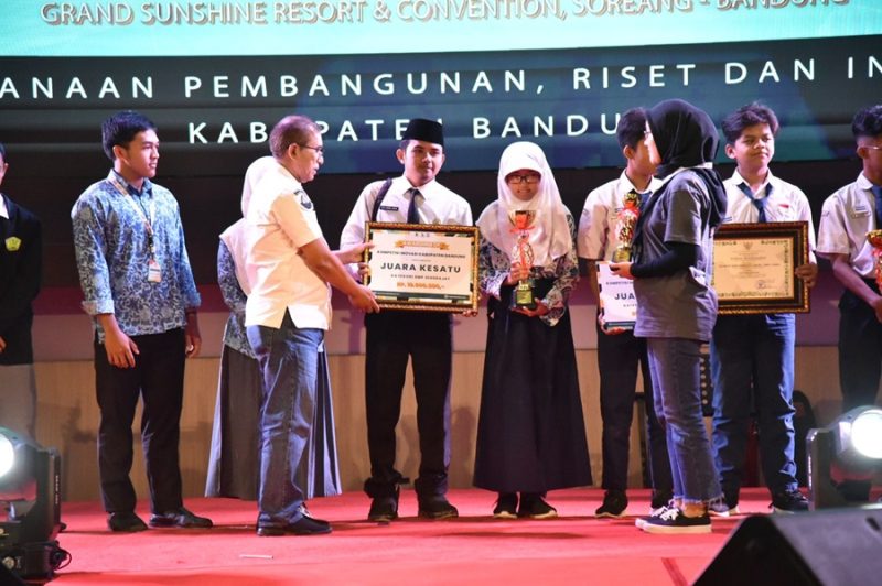 
Kepala Bapperida Kabupaten Bandung, Marlan menyerahkan penghagaan kepada pemenang KIKB 2024, yang digelar di Grand Sunshine Soreang, Rabu (30/10/2024).(Foto: diskominfo) 
