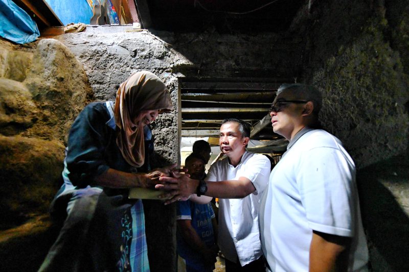 
Pj Gubernur Jawa Barat Bey Machmudin menyalami seorang nenek saat meninjau rumah warga yang kebanjiran di Kelurahan Sukawarna, Kota Bandung, Sabtu (25/1/2025).(Foto: Biro Adpim Jabar)