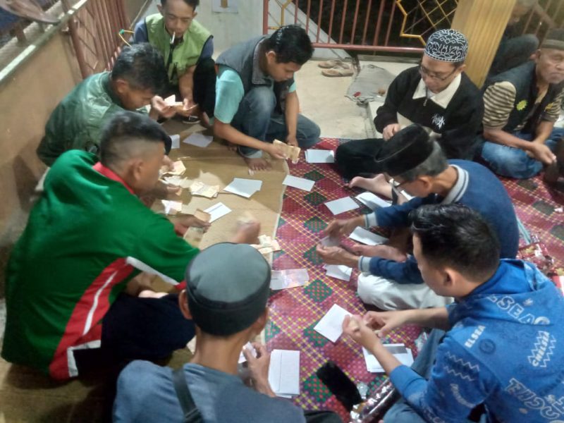 
Amilin Zakat Fitrah DKM Binaul Makmur, Kampung Kiaraeyeuh, Desa Banyusari, Kecamatan Katapan, Kabupaten Bandung, Jawa Barat, sibuk memasuan uang kedalam amplop untuk diberikan kepada para mustahik, Minggu (30/4/2025). Mereka bekerja  melaksanakan Amanah para muzakki yang telah menitipkan zakat fitrahnya. (Foto: maji/dara)
