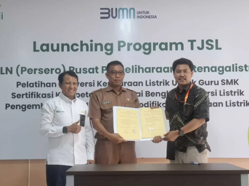 GM Pusharlis PT PLN (Persero) Suroso (baju putih), Kepala SMKN I Cisarua, Uung Syarif Kurnia tengah menunjukan  MoU antara SMKN I Cisarua dengan CV Hidtex (pabrik kendaraan listrik)(Foto: Istimewa)